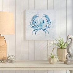 a white table topped with two vases filled with plants and a painting on the wall