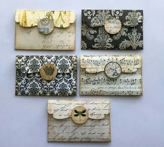 four different types of envelopes with paper and buttons on them, all decorated in black and gold