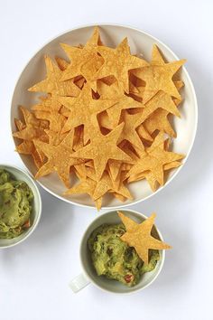 chips and guacamole in small bowls on a white plate with star shaped crackers