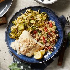 a blue plate topped with fish and vegetables