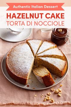 a cake on a plate with nuts around it and the words hazelnut cake torta di nocciole