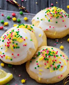 three lemon cookies with white frosting and sprinkles