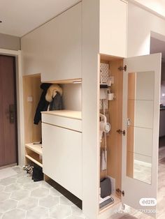 an open closet with clothes and shoes on it in a room that has white tile flooring