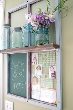 some mason jars with flowers and pictures on them are sitting on a shelf next to a chalkboard