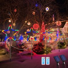 christmas lights on trees and houses in the snow