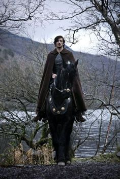 a man riding on the back of a black horse