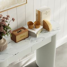 a white table topped with books and vase filled with flowers