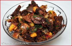 a glass bowl filled with meat and vegetables