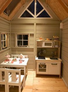 a small kitchen with wooden floors and white cabinets in the ceiling, along with an open window