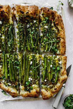 asparagus and goat cheese quiche on parchment paper with serving utensils