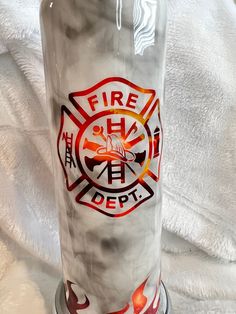 the fire department logo is painted on an old glass cup that has been turned into a candle holder