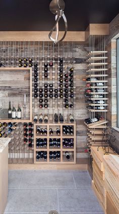 a wine cellar filled with lots of bottles and wooden shelves next to a counter top