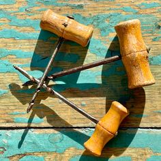 four wooden pegs are arranged in the shape of an x on a blue painted wood surface