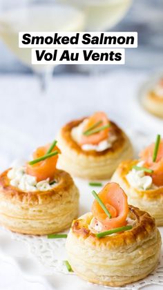 small appetizers are arranged on a plate with wine glasses in the back ground