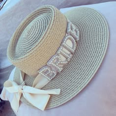 a hat with the word bride written on it and a bow at the top is sitting on a bed