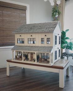 a doll house sitting on top of a wooden bench