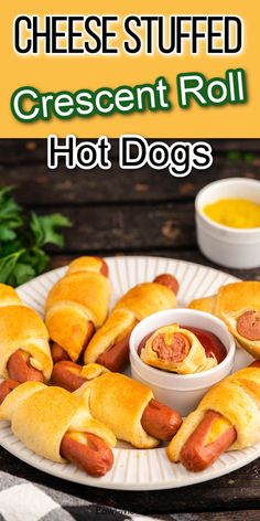 hot dogs wrapped in crescent rolls on a plate with mustard and ketchup for dipping