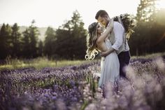 a bride and groom kissing in a field of lavenders with the sun behind them