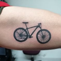 a man's arm with a bicycle tattoo on it