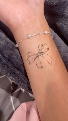 a woman's wrist with a small tattoo on it