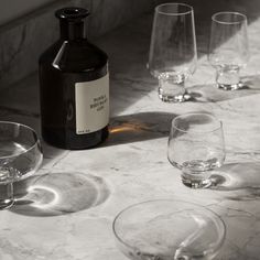 several empty wine glasses and a bottle on a marble table