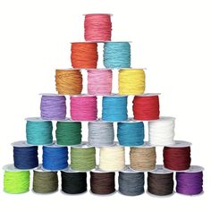 many spools of thread are stacked on top of each other in different colors