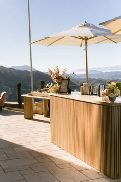 an outdoor bar with umbrellas and flowers on it