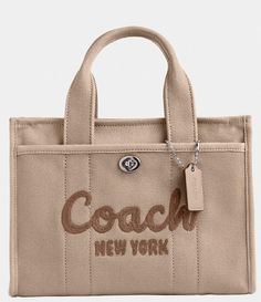 From COACH&#x2C; the Small Cargo Tote 26 Bag features:Canvas&#x2C; grosgrain&#x2C; and recycled leatherZip-top closureFabric liningHandles with 4" dropOutside turn-lock and snap pocketsDetachable strap with 24" drop for shoulder or crossbody wearFits an iPadApprox.: 10.25" L x 7.75" H x 5" WImported. Cuddle Season, Baggage Claim, Coach Tote Bags, Embroidered Canvas, Coach New York, Coach Tote, Small Tote Bag, Bags Aesthetic, Birthday Wishlist