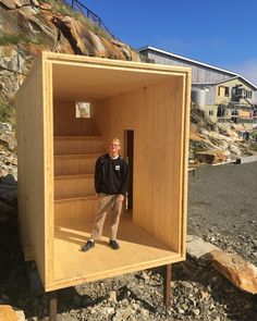 a man standing in a small wooden structure