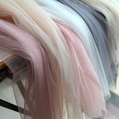 several different colors of tulle hanging on a rack