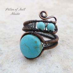 a wire wrapped ring with turquoise beads on it