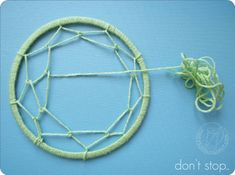 a close up of a piece of yarn on a blue surface with an object in the middle