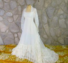 This is a vintage wedding dress from the early 80's. Queen Anne neckline. Lace bodice with sheer lace sleeves. Slightly Empire waist. Sheer skirt with ruffles. Tiered ruffles in the back leading down to the train. Excellent condition. Fits up to a 34" bust, 27" waist and up to 38" hips. Length is about 55" from top of shoulder to bottom front edge. Add about 23" to the back length for the train. 80s Wedding, Queen Anne Neckline, Skirt With Ruffles, Vintage Wedding Dress, Etsy Wedding Dress, Sheer Skirt, Wedding Aesthetic, Lace Bodice, Wedding Dresses Vintage