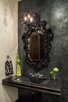 a bathroom sink sitting under a mirror next to a black counter