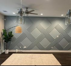 an empty room with a ceiling fan and two lights on the ceiling, next to a rug