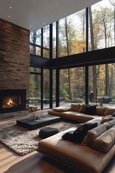 a living room with large windows and a couch in front of the fire place,