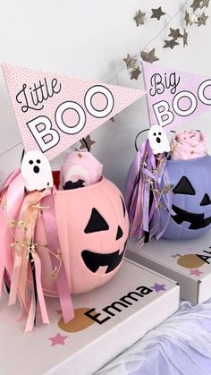 two halloween pumpkins sitting on top of boxes with little boo book signs above them