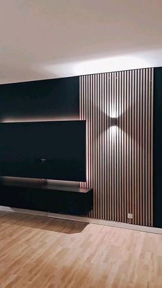 an empty living room with wood floors and black walls