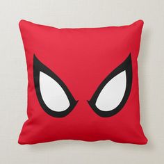 a red pillow with white eyes and black eyelashes on the front, which is part of a spider - man costume