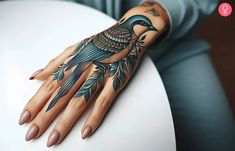 a woman's hand with tattoos on it and a bird sitting on the arm