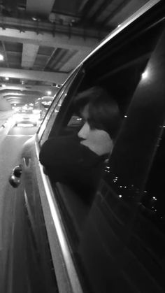 a woman is sitting in the passenger seat of a car and looking out the window