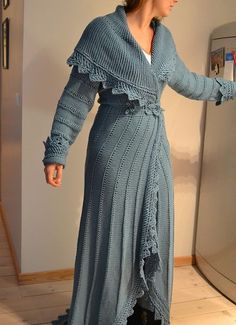 a woman standing in front of a refrigerator wearing a long blue dress with ruffles