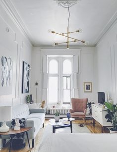 a living room filled with furniture and a chandelier