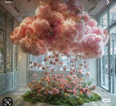 an artistic display with pink flowers hanging from the ceiling