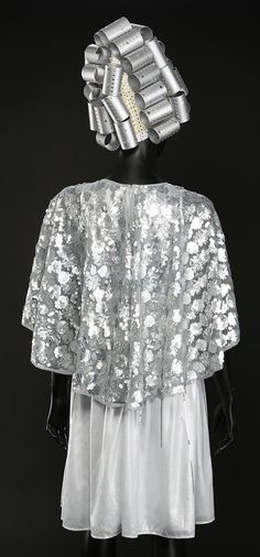 the back of a woman's dress with silver sequins and hair clips on her head