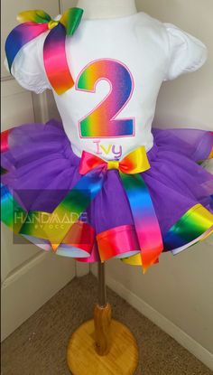 Rainbow Tutu Outfit, Custom Birthday Outfit, Toddler's tutu, Rainbow Tutu, Kids Birthday Tutu, Tutu With Shirt, Kids Custom Tutu Set This outfit is rainbow  themed. Perfect for a rainbow party. The shirts are 100%  ring spun combed cotton & run true to size. This shirt is available is short sleeve & long sleeve This shirt is embroidered with the childs age This out fit can be personalized for any birthday age. Just enter info in the personalization box This shirt is boutique style This set will include the nylon bow, tutu & shirt. All orders are made to order! Tutu sizes are:  6-12 months 12-18 months 2T  3T 4T 5T **You can always message me &  or add it to the personalization box** Machine Wash Cold & Hang Dry Please allow 10 business days for processing. Then allow another 5-7 days to ar Fun White Tutu Dress For Birthday, Playful Purple Tutu Dress For Birthday, Rainbow Tutu Dress For Birthday, Cute Rainbow Tutu Dress For Birthday, Tutu Shirt, Rainbow Tutu, Toddler Tutu, Tutu Outfits, Rainbow Party