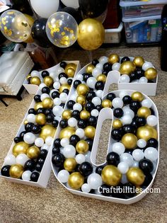 a large number made out of balloons on top of a table next to other decorations