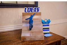 a wooden table topped with a paper bag and a blue figure on top of it