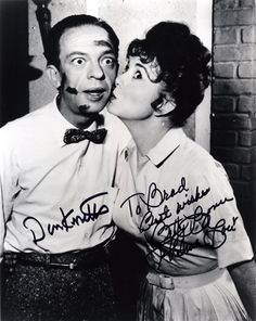 an old black and white photo of a man kissing a woman's cheek with the caption, donuts on his shirt