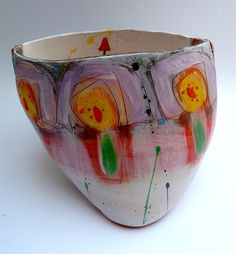 a bowl that has been painted with different colors and shapes on the inside of it